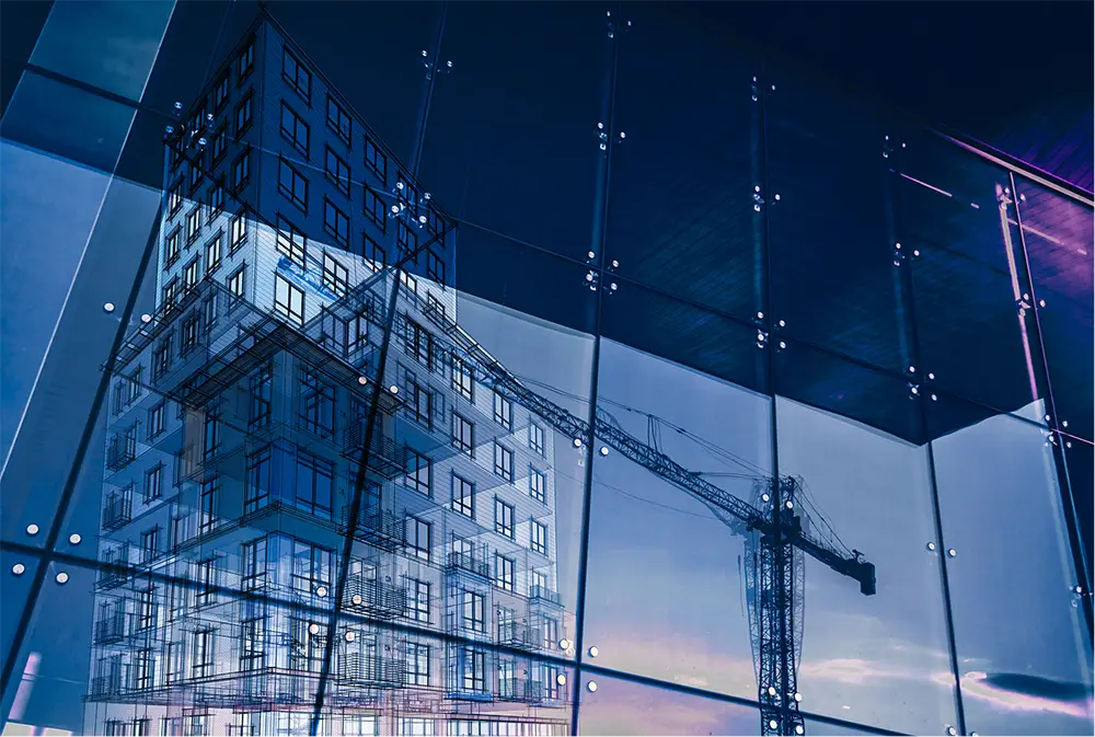 A building's reflection is visible in a large glass window, showcasing the structure's design and the surrounding environment.